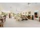 Spacious living room with carpet, neutral furniture, ceiling fans, and views of the backyard at 60 N Oxford Dr, Englewood, FL 34223