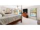 Main bedroom with a four-poster bed, TV and private outdoor access with pool views at 60 N Oxford Dr, Englewood, FL 34223