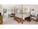 Main bedroom with a four-poster bed, bench and views of the backyard at 60 N Oxford Dr, Englewood, FL 34223