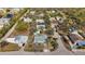 A sprawling aerial view of a light blue single-story home nestled in a tree-lined neighborhood with nearby amenities at 7035 Duke St, Englewood, FL 34224