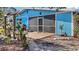 Charming backyard featuring wooden deck, blue siding, and a variety of potted plants at 7035 Duke St, Englewood, FL 34224