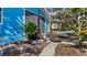The backyard shows a wooden deck, a walkway, landscaping, and part of a blue home with a screened-in room at 7035 Duke St, Englewood, FL 34224