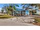 The exterior shows the blue home, a screened-in porch, and landscaping, all surrounded by a sandy yard at 7035 Duke St, Englewood, FL 34224