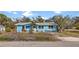 Charming light blue single-story home with a quaint front yard and ample natural light, creating a welcoming curb appeal at 7035 Duke St, Englewood, FL 34224