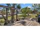 The front yard features a deck with plants, a decorative wooden structure, and views of the street and neighborhood at 7035 Duke St, Englewood, FL 34224