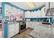 White kitchen with stainless steel appliances, granite countertops and view to the living area at 7035 Duke St, Englewood, FL 34224