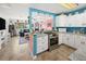 Bright kitchen featuring white cabinets, granite countertops, and stainless steel appliances at 7035 Duke St, Englewood, FL 34224