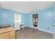 Bright bedroom features wood-look flooring, blue accent walls and plenty of natural light at 7035 York St, Englewood, FL 34224