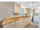 Well-lit kitchen with wood countertops, stainless steel sink, and ample storage with an adjacent laundry room at 7035 York St, Englewood, FL 34224