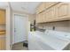 Spacious laundry area equipped with washer, dryer, and cabinets providing ample storage solutions at 7035 York St, Englewood, FL 34224
