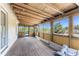 Enclosed patio featuring a wood floor and ceiling with walls of windows and a screen door at 7035 York St, Englewood, FL 34224