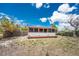 Charming home with white vinyl siding, a screened porch, and a grass backyard at 7035 York St, Englewood, FL 34224