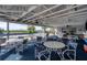 Outdoor patio featuring tables with seating, ceiling fans, and views of the community pool and manicured landscaping at 7070 Placida Rd # 1230, Placida, FL 33946