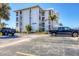 Front exterior of a condo building displaying unit number, parking spaces, landscaping, and community docks at 7070 Placida Rd # 1230, Placida, FL 33946