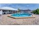 Large community swimming pool surrounded by poolside lounging and an outdoor bar, with beautiful building architecture at 7070 Placida Rd # 1230, Placida, FL 33946