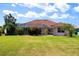 Spacious backyard with a screened-in lanai, featuring lush greenery and a well-manicured lawn at 76 Sportsman Rd, Rotonda West, FL 33947