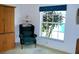 Bedroom featuring an armchair, window view, and a wooden storage unit, creating a cozy and functional space at 76 Sportsman Rd, Rotonda West, FL 33947