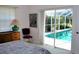 Bright bedroom featuring a sliding glass door leading to a screened-in pool area, adding to the room's appeal at 76 Sportsman Rd, Rotonda West, FL 33947