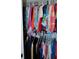 Closet full of colorful clothing hanging on rods at 76 Sportsman Rd, Rotonda West, FL 33947