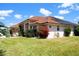 A lovely home is displayed from an angle that highlights its tile roof and beautifully landscaped yard at 76 Sportsman Rd, Rotonda West, FL 33947