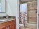 This bathroom features a granite vanity, tile backsplash, and a tub and shower combination with a floral shower curtain at 8152 Little Gasparilla Is, Placida, FL 33946