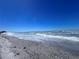 Sandy beach landscape with gentle waves and seashells along the shoreline at 8152 Little Gasparilla Is, Placida, FL 33946