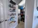Narrow laundry room with stacked washer and dryer, shelving for storage and a wire rack on the door at 8152 Little Gasparilla Is, Placida, FL 33946
