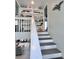 View of the living room with custom shelving leading up the stairs in this bright home at 8152 Little Gasparilla Is, Placida, FL 33946