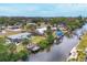 Expansive view of a waterfront home with a private dock, canal access, and lush tropical landscaping at 832 E 4Th St, Englewood, FL 34223