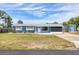 Quaint single-story home with a well-kept lawn, a long driveway, and a detached storage shed at 832 E 4Th St, Englewood, FL 34223
