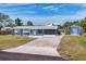 Charming blue single-story home with a well-maintained lawn, long driveway, and storage shed at 832 E 4Th St, Englewood, FL 34223