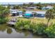 Waterfront home featuring a private dock, mature palm trees, and a covered outdoor area with a blue awning at 832 E 4Th St, Englewood, FL 34223