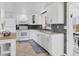 Modern kitchen with white cabinets, an island with stools, and stainless steel appliances at 832 E 4Th St, Englewood, FL 34223