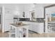 Well-lit kitchen featuring white cabinetry, an island with bar stools, and a stylish backsplash at 832 E 4Th St, Englewood, FL 34223