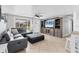 Bright living room with a ceiling fan, tile flooring, and a stylish gray sectional sofa at 832 E 4Th St, Englewood, FL 34223