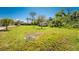 Large, grassy backyard with a scattering of trees offering ample space for outdoor activities at 941 Allen Ave, Englewood, FL 34223