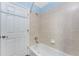 Bright bathroom featuring a tub with tiled walls, a toilet, and shower head at 941 Allen Ave, Englewood, FL 34223