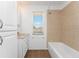 Bright bathroom featuring a white vanity and a shower-tub combo with beige tile surround at 941 Allen Ave, Englewood, FL 34223