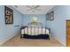 Comfortable bedroom with a ceiling fan, blue walls, neutral carpet, and natural light from the window at 941 Allen Ave, Englewood, FL 34223