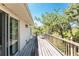 Spacious wooden deck with lush foliage views, accessible through sliding glass doors at 941 Allen Ave, Englewood, FL 34223
