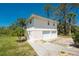 Lovely home exterior with a spacious two-car garage, side stairway, well-maintained lawn, and scenic surroundings at 941 Allen Ave, Englewood, FL 34223