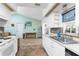 Open kitchen blending seamlessly into the living area with white cabinets, earth tone flooring, and stainless steel appliances at 941 Allen Ave, Englewood, FL 34223