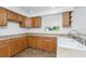 Well-lit kitchen featuring wooden cabinets, neutral countertops, and a window offering a pleasant view at 941 Allen Ave, Englewood, FL 34223