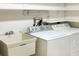 Functional laundry area equipped with a washing machine, sink, and storage space at 941 Allen Ave, Englewood, FL 34223