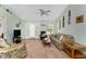 Inviting living room with neutral carpet and light green walls, featuring a ceiling fan and ample seating at 941 Allen Ave, Englewood, FL 34223