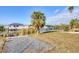 Spacious backyard with lush green grass, mature palm trees, a canal, and a covered boat lift at 15184 Aldama Cir, Port Charlotte, FL 33981