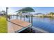 Dock with boat lift featuring green canopy at 15184 Aldama Cir, Port Charlotte, FL 33981