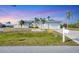 Charming single-story home with a well-manicured lawn and beautiful palm trees enhancing its curb appeal at 15184 Aldama Cir, Port Charlotte, FL 33981
