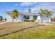 Lovely single-story home featuring a well-kept lawn and charming palm trees, enhancing its appeal at 15184 Aldama Cir, Port Charlotte, FL 33981