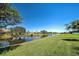 Backyard view featuring a pond, green grass, and landscaping at 1078 Boundary Blvd, Rotonda West, FL 33947